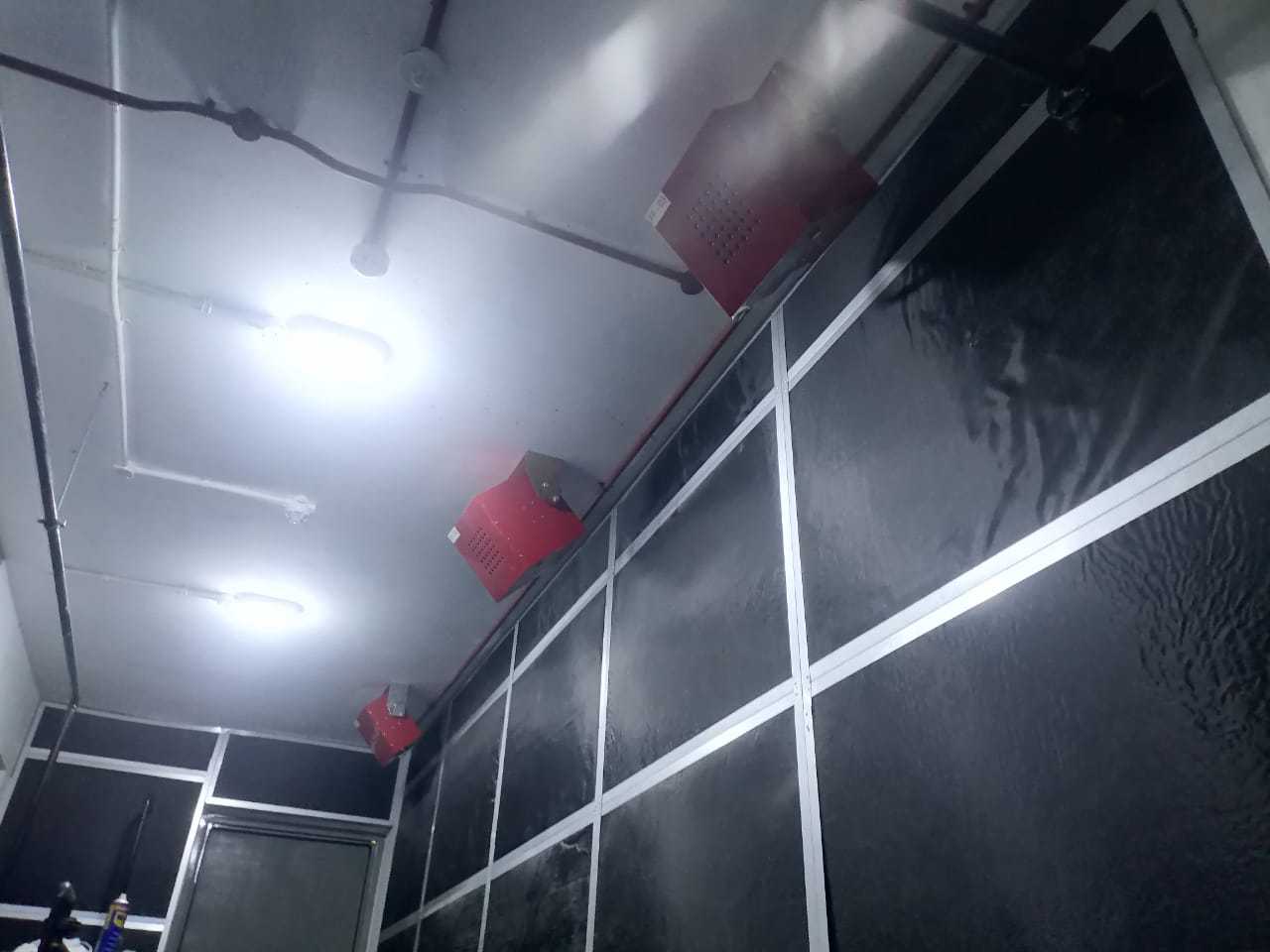 Installed fire suppression system units mounted above equipment in a protected room