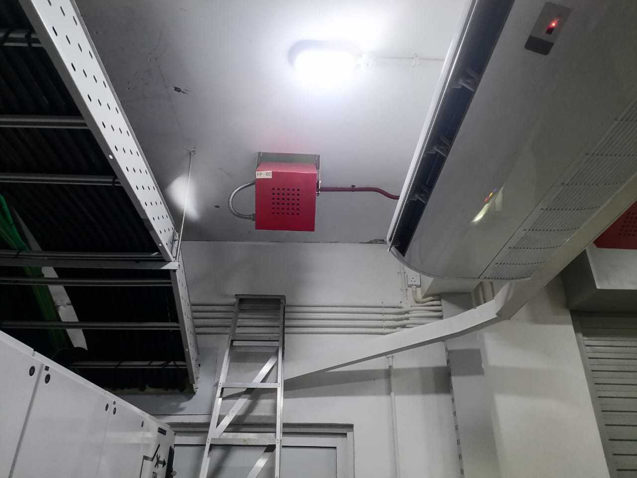 Fire suppression unit installed near air-conditioning and cable tray infrastructure