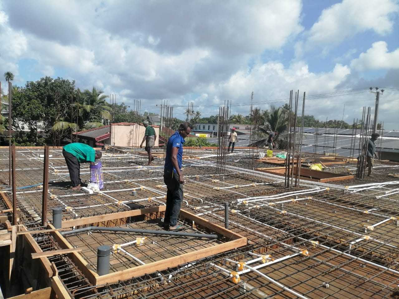 Workers preparing slab reinforcement and conduit routes at Trillium Apartment